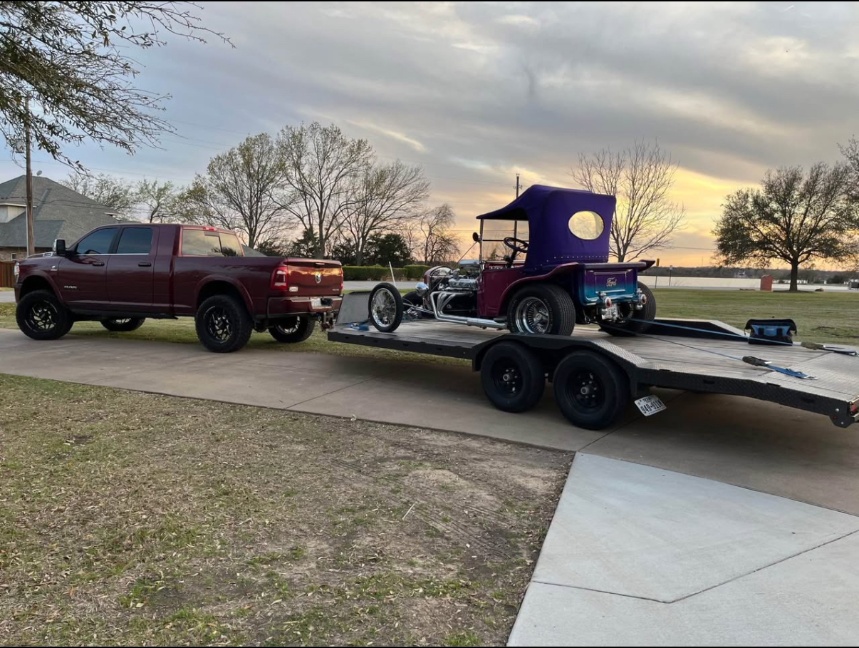 Ram truck hauling a classic car on a flatbed trailer